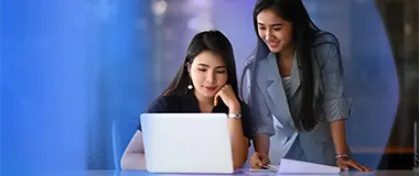 Two women working together on laptop – Hays Japan Salary Guide and market insights.
